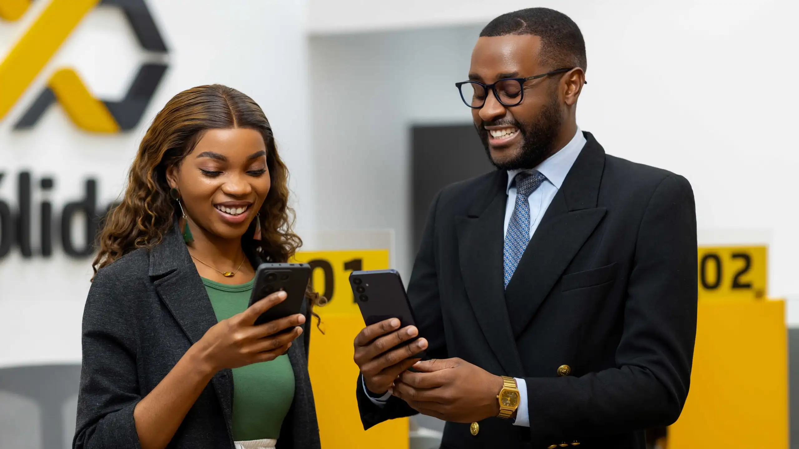Clientes sorrindo enquanto usam o app móvel do Microbanco Sólido